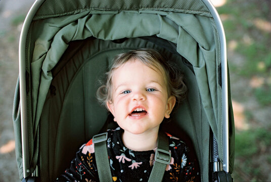 A little girl in a green buggy