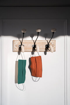 Two Colourful Masks Hang ing On A Door Rack.