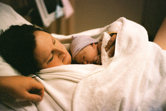 sweet little baby girl just born and laying on breast of mother