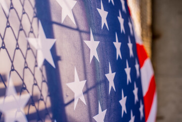 Illegal immigration concept  Background of transparent American flag behind a chain link fence and...