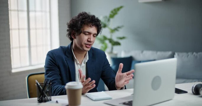 Asian businessman at team meeting with his employees. Male entrepreneur having video tele conference from home office during self-isolation 4k footage