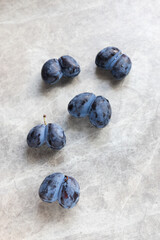 ugly organic blue double plums heart-shaped on a grey background