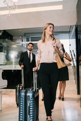 Business people arriving at hotel. - obrazy, fototapety, plakaty