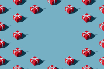 Christmas isometric pattern background banner with copy space. Minimal composition made of Christmas red gift box on blue background. Top view. Holiday New Year concept. Xmas presents, congratulations