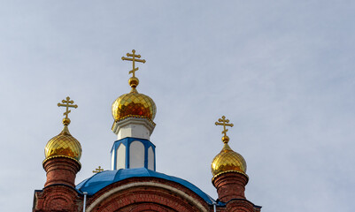 Fototapeta na wymiar Three golden domes with crosses of Orthodox Church