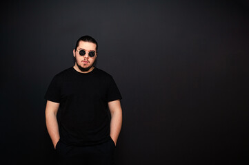 Obraz premium Young man on a background of black walls