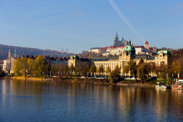 Autumn colorful Prague Lesser Town with gothic Castle above River Vltava in the sunny Day, Czech Republic