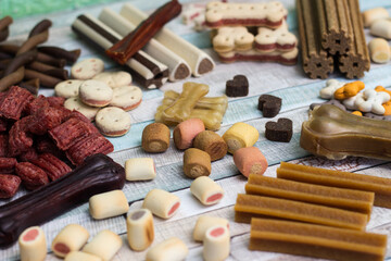 Pet food, snacks for dogs. Dog tasty colored biscuits on wooden background.