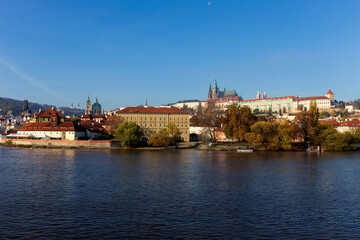 Obraz premium Autumn colorful Prague Lesser Town with gothic Castle above River Vltava in the sunny Day, Czech Republic