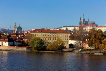 Autumn colorful Prague Lesser Town with gothic Castle above River Vltava in the sunny Day, Czech Republic