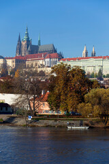 Autumn colorful Prague Lesser Town with gothic Castle above River Vltava in the sunny Day, Czech Republic