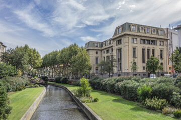 Obraz premium Beautiful promenade along La Bassa River flowing through the Perpignan city center. Perpignan, Pyrenees Orientales, France.