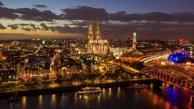 Aerial timelapse of Cologne Cathedral at night, with city lights and urban movement