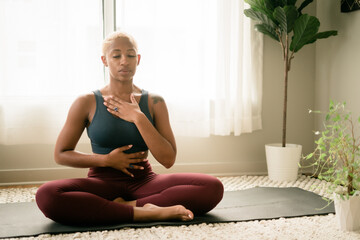 Black woman breathing and doing meditation at home