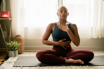 Black woman breathing and doing meditation at home