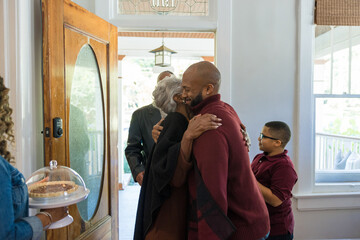 Grandmother and grandfather greet family for Thanksgiving wearing mask