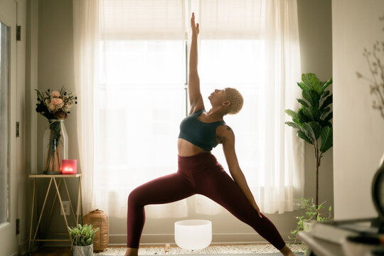 Young woman practices yoga at home