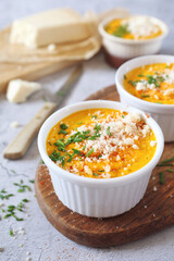 French cuisine.  Three servings of carrot flan with grated parmesan cheese