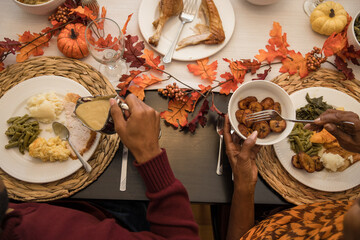 Overhead view of black hands eating Thanksgiving holiday meal