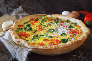 French cuisine. Quiche pie with broccoli, carrots, hot peppers and parmesan cheese