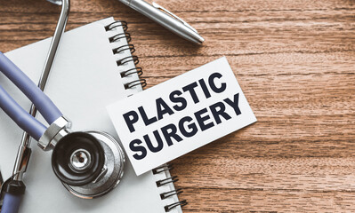 A card with text PLASTIC SURGERY on wooden doctor's table