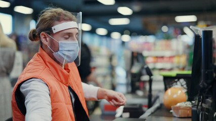 Bearded young cashier wearing respiratory mask face shield servicing young woman customer in supermarket grocery store during coronavirus quarantine. - Powered by Adobe