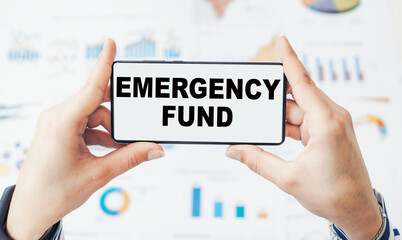Closeup on businessman holding a smartphone with text Emergency Fund