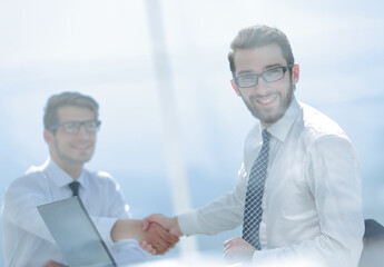 smiling businessman shaking hands with his partner