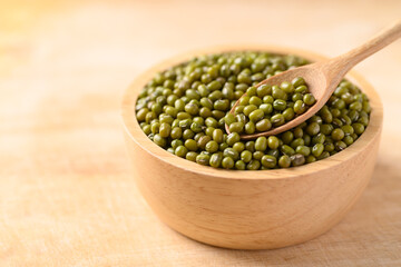 Mung bean with spoon in a bowl on wooden background