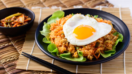 Kimchi fried rice with fried egg on top and fresh kimchi cabbage, Korean food