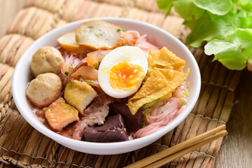 Thai food (Yen Ta Fo), Rice noodles soup with red sauce and fish tofu, pork ball and fried wonton in a bowl