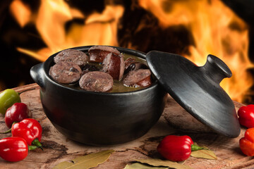 Feijoada. Traditional Brazilian food. Background with defocused fire.