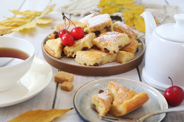 Austrian cuisine.  Torn pancake (or omelet)  kaiserschmarrn with sultana, powdered sugar dressing and cup of tea for sweet breakfast