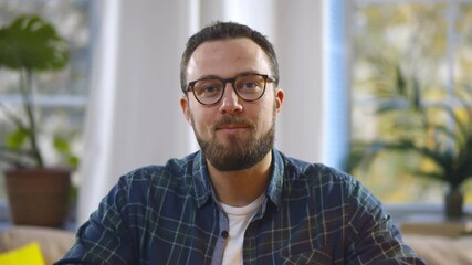 Portrait of handsome bearded man looking at speaking at camera having video call from home - Powered by Adobe
