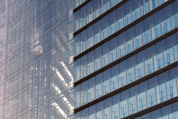 Blue tone and Close up detail of exterior facade with glass material of modern office buildings,...