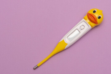 baby thermometer duck on a lilac background