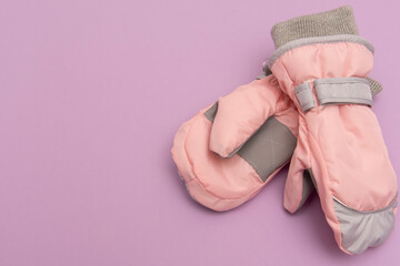 baby peach waterproof mittens on a lilac background