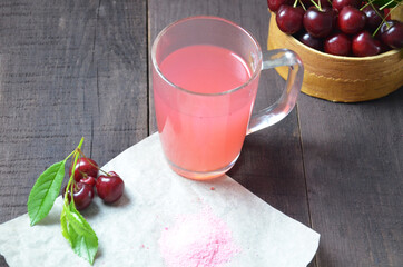 Kissel with cherries in a glass on an old wooden background, traditional russia or poland drink, berry jelly, mousse, summer pink drink