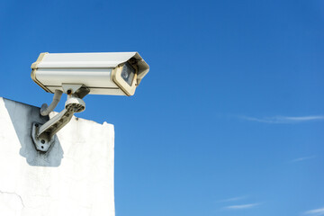 CCTV camera systems on a wall with copy space on blue sky on background. Concept of security, surveillance and monitoring.