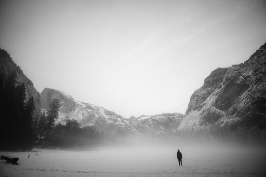 silhouette of a man walking between the mountains