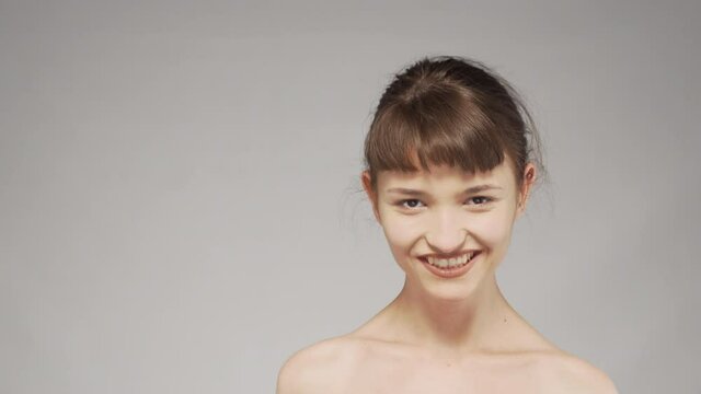 Video portrait of a cute girl in studio, smiling.