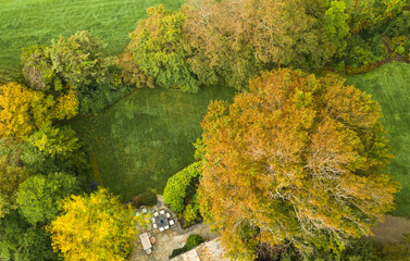 Aerial of  stone patio with table and chairs, formal landscaping during Fall.