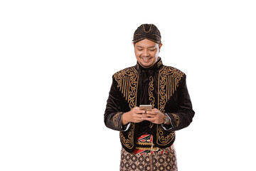 Portrait of a happy traditional Javanese man holding a cell phone. Isolated on white background