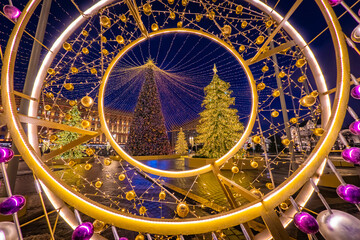 Year party. Shiny street decorations and Christmas trees. Christmas trees on a background of garlands and balloons. Festive evening in the capital of Russia. Moscow in the New year.