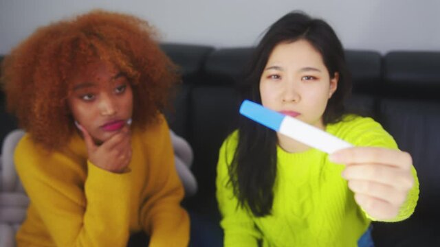 Disappointed lesbian couple looking at negative pregnancy test. Unsuccessful In vitro fertilization. High quality 4k footage