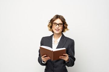 Business woman with notepad and glasses work light background cropped view of suit model.