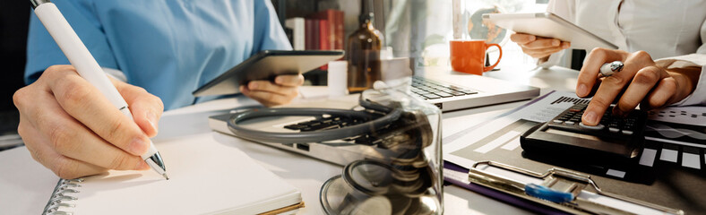 Medical technology concept The doctor works with mobile phones, headphones and tablets. Digital laptop Pressing the calculator in the modern office at the hospital in the morning