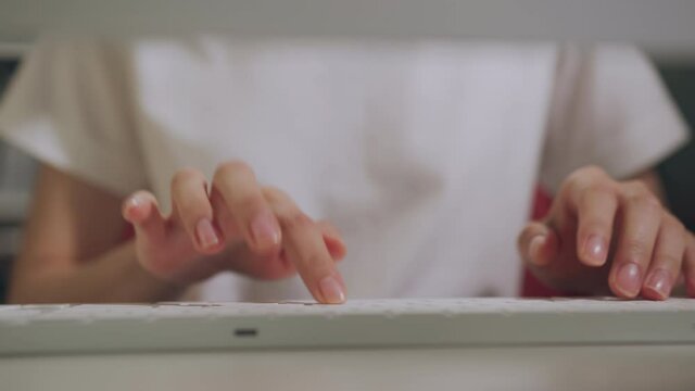 Close up of hand typing on the computer keyboard, on wooden desk.