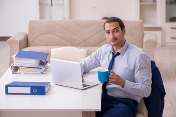 Young male employee working from home in pandemic concept