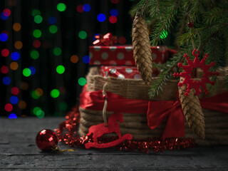Gift box under a spruce tree on a wooden floor with a bokeh background.